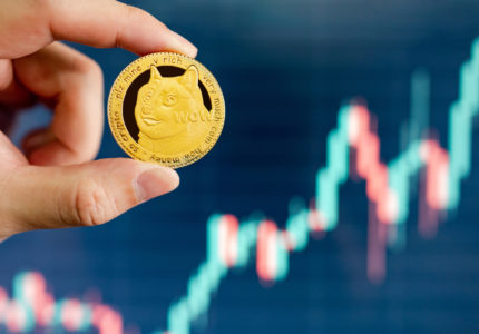 Hand,Holding,Gold,Dogecoin,With,Blurred,Candlestick,Chart,In,The
