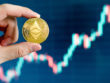 Hand,Holding,Gold,Eth,Coin,With,Blurred,Candlestick,Chart,In