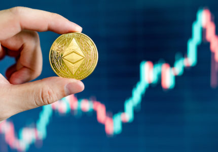 Hand,Holding,Gold,Eth,Coin,With,Blurred,Candlestick,Chart,In