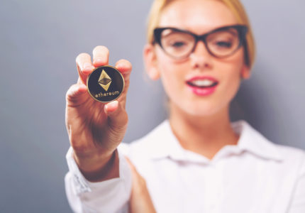 Woman,Holding,A,Physical,Ethereum,Coin,Cryptocurrency,In,Her,Hand